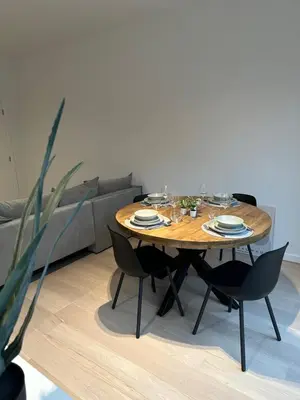 a wooden table in a living room with black chairs at Märch - Mechelen Goat 6 in Mechelen