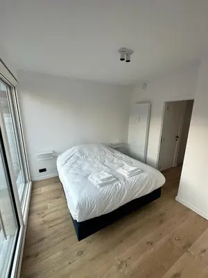 a bedroom with a bed with white sheets on it at Märch - Mechelen Goat 6 in Mechelen