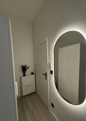a white room with a mirror and a door at Studio à Ixelles - Viaduc in Brussels