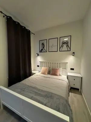 a bedroom with a large bed and two pictures on the wall at Studio à Ixelles - Viaduc in Brussels
