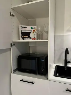 a kitchen with a black microwave and a shelf at Studio à Ixelles - Viaduc in Brussels