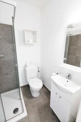 a white bathroom with a toilet and a sink at FLATS aparthotel in Brussels