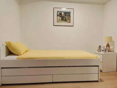 a bed in a room with a white wall at Bright & Cozy Appartment in Brussels in Brussels