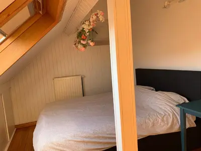 a bedroom with a bed and a flower arrangement on the wall at Une belle étage à Stockel with charming patio in Brussels