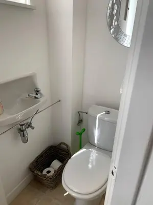a white bathroom with a toilet and a sink at Une belle étage à Stockel with charming patio in Brussels