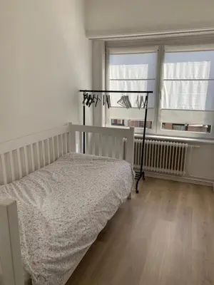 a bedroom with a bed and two windows at Une belle étage à Stockel with charming patio in Brussels