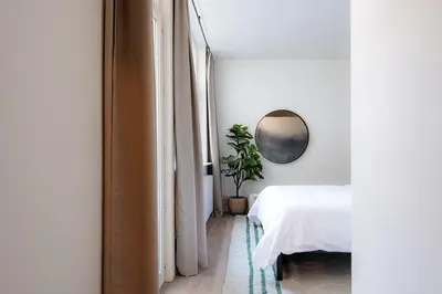 a bedroom with a bed and a mirror and a plant at Cathedral view apartment in Antwerp