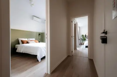a bedroom with a bed and an open door at Cathedral view apartment in Antwerp