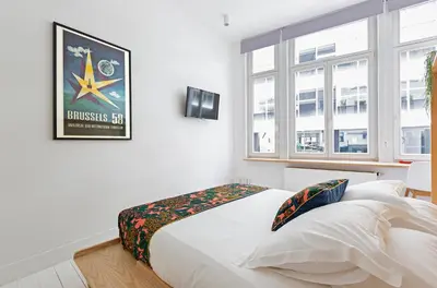 a bedroom with a white bed with a picture on the wall at Happy Boutique Hotel - Grand Place in Brussels