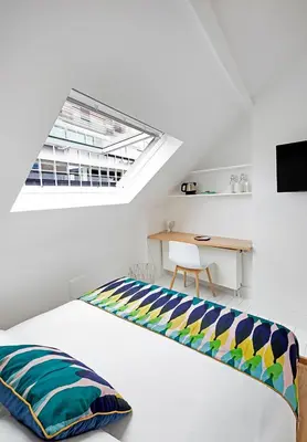 a white bedroom with a bed with a skylight at Happy Boutique Hotel - Grand Place in Brussels