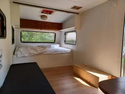 a small room with a bed and two windows at De Vijver in Geel