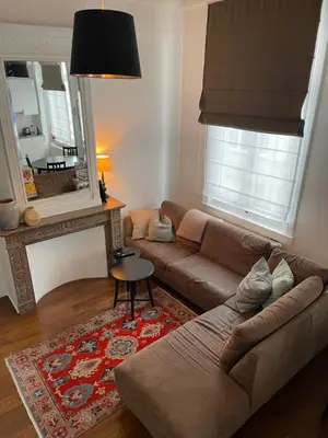 a living room with a couch and a mirror at Holiday Home Amélie in Antwerp
