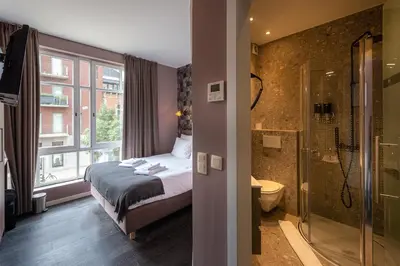 a bedroom with a bed and a bathroom with a shower at Dock 29 in Antwerp