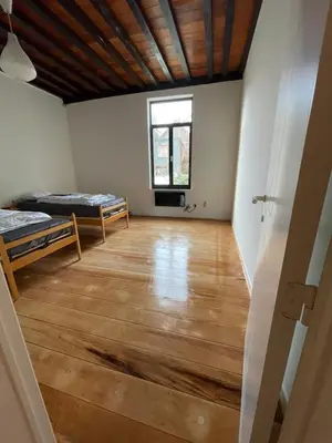 an empty room with two beds and a window at De Wijngaard in Ghent