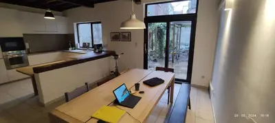 a kitchen with a wooden table with a laptop on it at De Wijngaard in Ghent