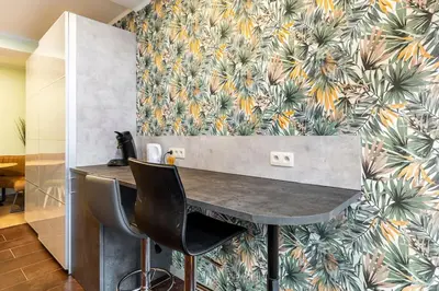 a table and two chairs in a room with a wallpaper at Magnolia Green Garden New and fully equipped in Brussels