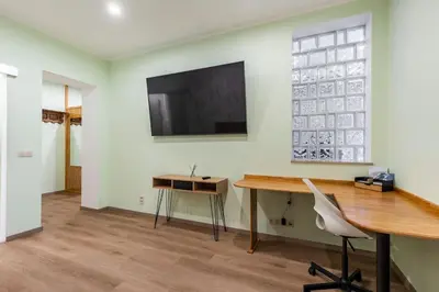 an office with a desk and a television on a wall at Magnolia Green Garden New and fully equipped in Brussels