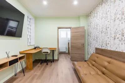a living room with a couch and a desk at Magnolia Green Garden New and fully equipped in Brussels