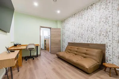 a living room with a couch and a desk at Magnolia Green Garden New and fully equipped in Brussels