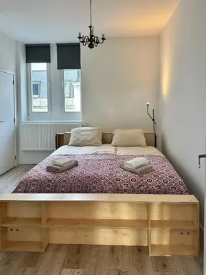 a bedroom with a large bed with two pillows on it at Stay in Artist’s Gallery in Antwerp