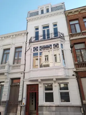 a white building with a balcony on top of it at Stay in Artist’s Gallery in Antwerp