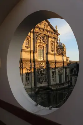 a large building is seen through a round mirror at The View in Antwerp