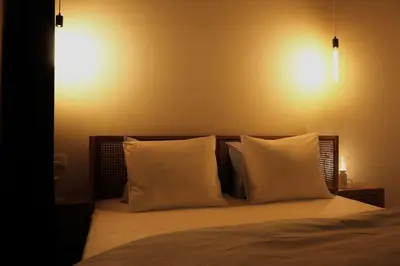 a bed with two pillows and two lights on the wall at The View in Antwerp