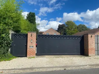 a garage with a black gate and a brick house at Flat vane & Soun in Waterloo