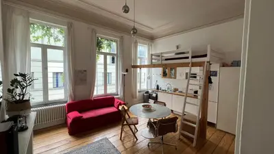 a living room with a red couch and a table at Arti Appart Louise/Flagey/Centre in Brussels