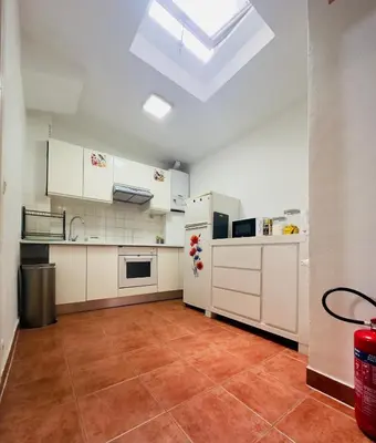 a large kitchen with white cabinets and a skylight at Modern & Comfortable City Center Oasis~King Bed ! in Brussels