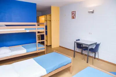 a room with two bunk beds and a desk at Hostel Blauwput Leuven in Leuven