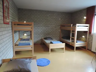 a room with three bunk beds in it at Hostel Blauwput Leuven in Leuven