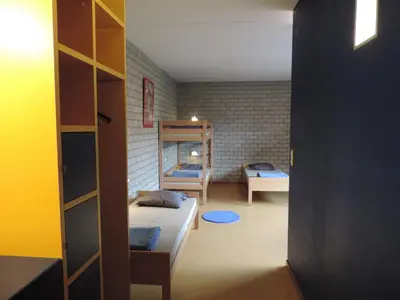 a bedroom with two beds and a bunk bed at Hostel Blauwput Leuven in Leuven