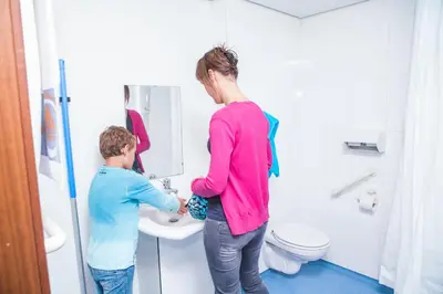 a woman and a child standing in a bathroom at Hostel Blauwput Leuven in Leuven