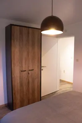 a room with a wooden closet and a light fixture at Vakantiewoning 't Bruggeneindje in Heist-op-den-Berg