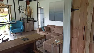 a living room with a couch and a table at Vakantiewoning 't Bruggeneindje in Heist-op-den-Berg