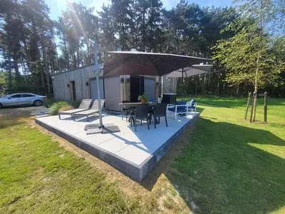 a patio with a table and chairs and an umbrella at Vakantiewoning 't Bruggeneindje in Heist-op-den-Berg
