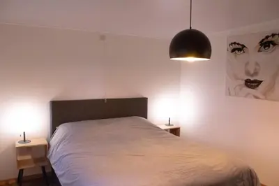 a bedroom with a bed with two night stands and two lamps at Vakantiewoning 't Bruggeneindje in Heist-op-den-Berg
