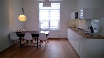 a kitchen with a table and chairs in a room at Almost White, Near Train, Metro n7688 in Brussels