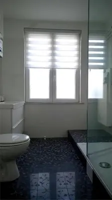 a bathroom with a toilet and a shower and a window at Almost White, Near Train, Metro n7688 in Brussels