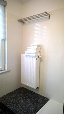 a room with a pile of towels and a radiator at Almost White, Near Train, Metro n7688 in Brussels