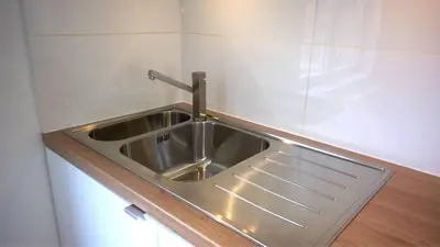 a stainless steel sink with a faucet in a kitchen at Almost White, Near Train, Metro n7688 in Brussels