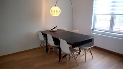 a dining room with a black table and white chairs at Almost White, Near Train, Metro n7688 in Brussels