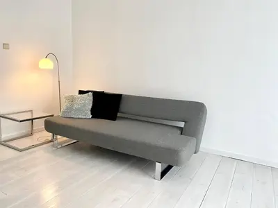 a couch sitting in a room with a lamp at Wit II, Near Metro, Train n7670 in Brussels