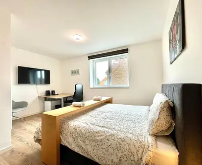 a bedroom with a bed and a desk and a window at Il Casolare in Beersel
