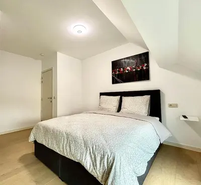 a bedroom with a bed and a painting on the wall at Il Casolare in Beersel