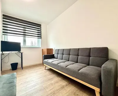 a living room with a couch and a television at Il Casolare in Beersel