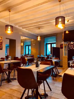 a dining room with tables and chairs and windows at Il Casolare in Beersel