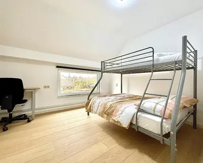 a bedroom with a bunk bed and a desk at Il Casolare in Beersel