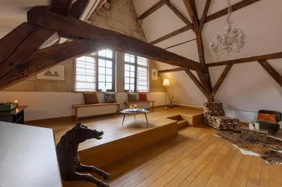 a large living room with wooden floors and a large window at Chic Penthouse Grand-Place in Brussels